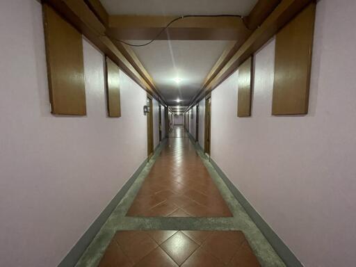 long hallway in a building with tiled floor