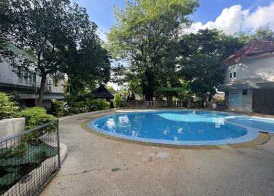 Outdoor pool area with surrounding greenery