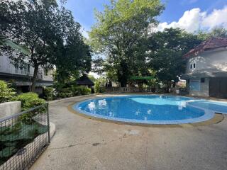 Outdoor pool area with surrounding greenery