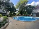 Outdoor pool area with surrounding greenery