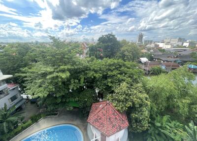 Aerial view of a property with a swimming pool and lush greenery