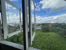 Open window view of cityscape with green vegetation