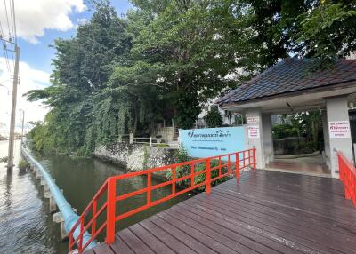 Entrance of a property with surrounding greenery and a water body