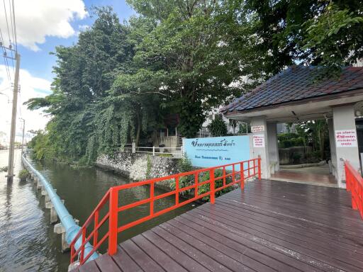 Entrance of a property with surrounding greenery and a water body