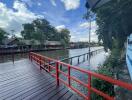 Scenic view of riverside with wooden deck and red railing