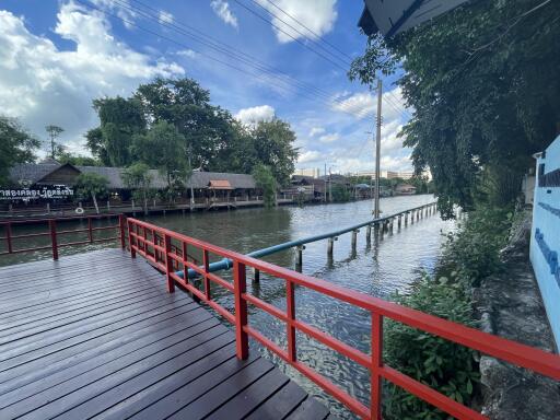 Scenic view of riverside with wooden deck and red railing