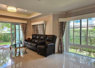 Spacious living room with large windows and leather sofa