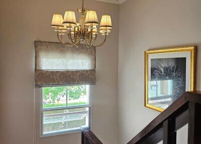 Well-lit staircase with a chandelier and a window