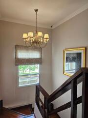 Well-lit staircase with a chandelier and a window