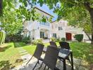 Two-story house with garden and outdoor dining area