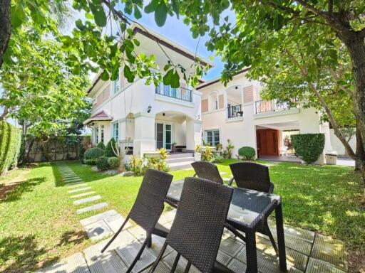 Two-story house with garden and outdoor dining area