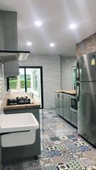 Modern kitchen with stainless steel appliances and colorful tiled floor