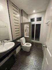 Modern bathroom with sink, toilet, shower, and large mirror