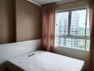 Bedroom with a large window and minimal furnishings