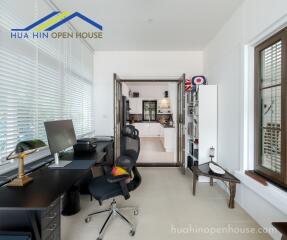 Home office area with desk, chair, and view into the kitchen