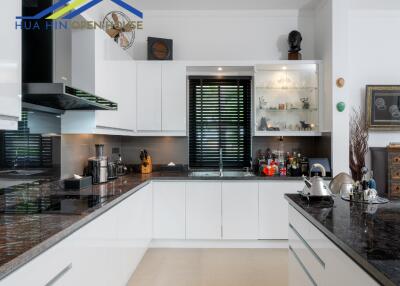 Modern kitchen with white cabinets and dark countertops