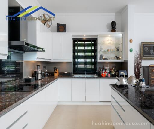 Modern kitchen with white cabinets and dark countertops