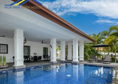 Outdoor swimming pool area with lounge chairs and covered patio