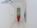 Bright hallway with white walls, a window with blinds, and a decorative red vase with plants