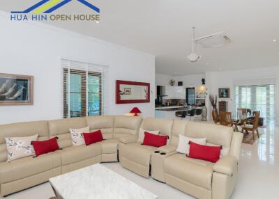 Spacious living room with sofas, coffee table, and open kitchen