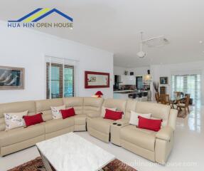 Spacious living room with sofas, coffee table, and open kitchen