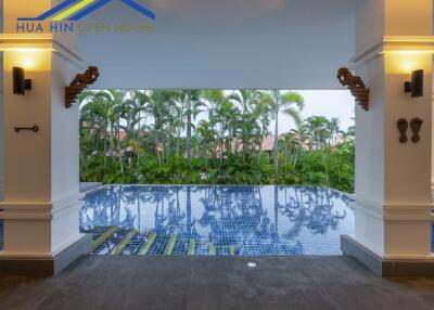 Covered outdoor pool area with lush greenery