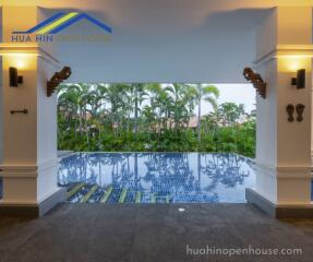 Covered outdoor pool area with lush greenery