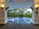 Covered outdoor pool area with lush greenery