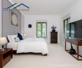 Modern bedroom with a large bed, ample natural light, and elegant furnishings