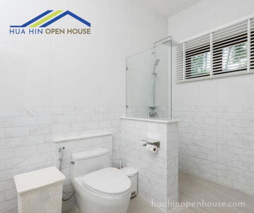 Modern bathroom with glass shower and white tiles