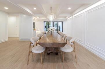 Spacious dining area with a large wooden table and elegant chairs