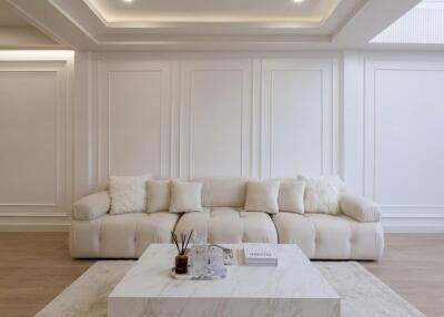 Elegant living room with beige couch, marble coffee table, and stylish wall paneling