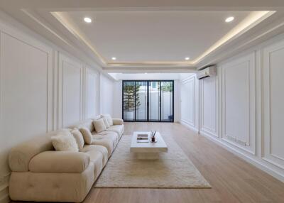 Modern living room with comfortable beige sofa, coffee table and large window