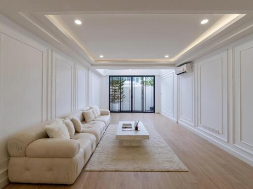 Modern living room with comfortable beige sofa, coffee table and large window