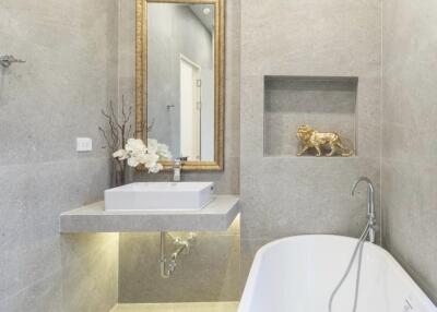 Modern bathroom with bathtub, sink, and decorative elements