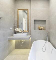 Modern bathroom with bathtub, sink, and decorative elements