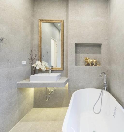 Modern bathroom with bathtub, sink, and decorative elements