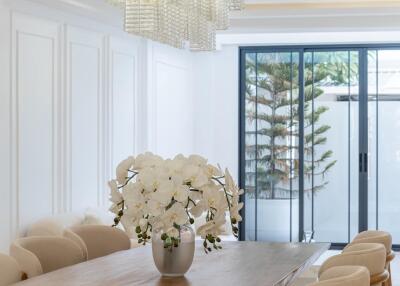 Dining room with wooden table, modern chandelier, and large windows