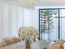 Dining room with wooden table, modern chandelier, and large windows