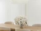 Dining room with wooden table, beige chairs, and chandelier