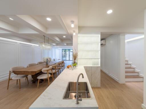 Modern kitchen and dining area with a marble countertop and wooden dining table