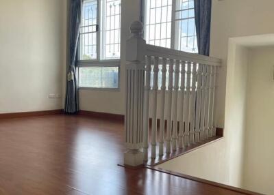 Staircase leading to a brightly lit room with large windows and wooden flooring