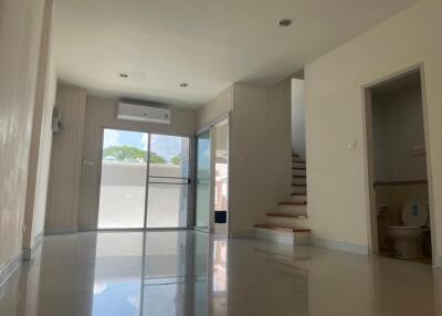 Spacious living area with large windows and staircase