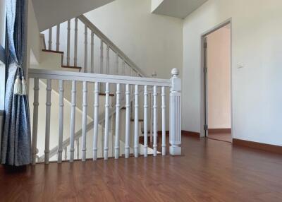 Staircase with wooden flooring and white railings