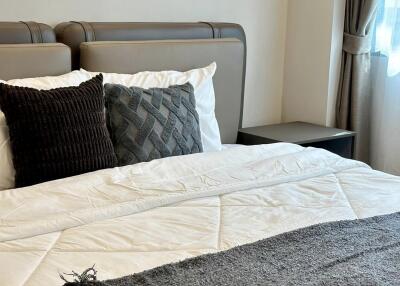 Modern bedroom with a neatly made bed and decorative pillows