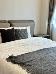 Modern bedroom with a neatly made bed and decorative pillows