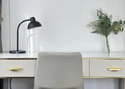 Modern study area with desk lamp, chair, and potted plant