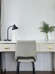 Modern study area with desk lamp, chair, and potted plant