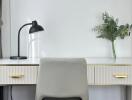 Modern study area with desk lamp, chair, and potted plant