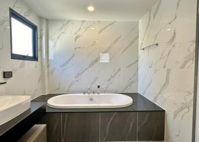 Modern bathroom with large bathtub and marbled walls